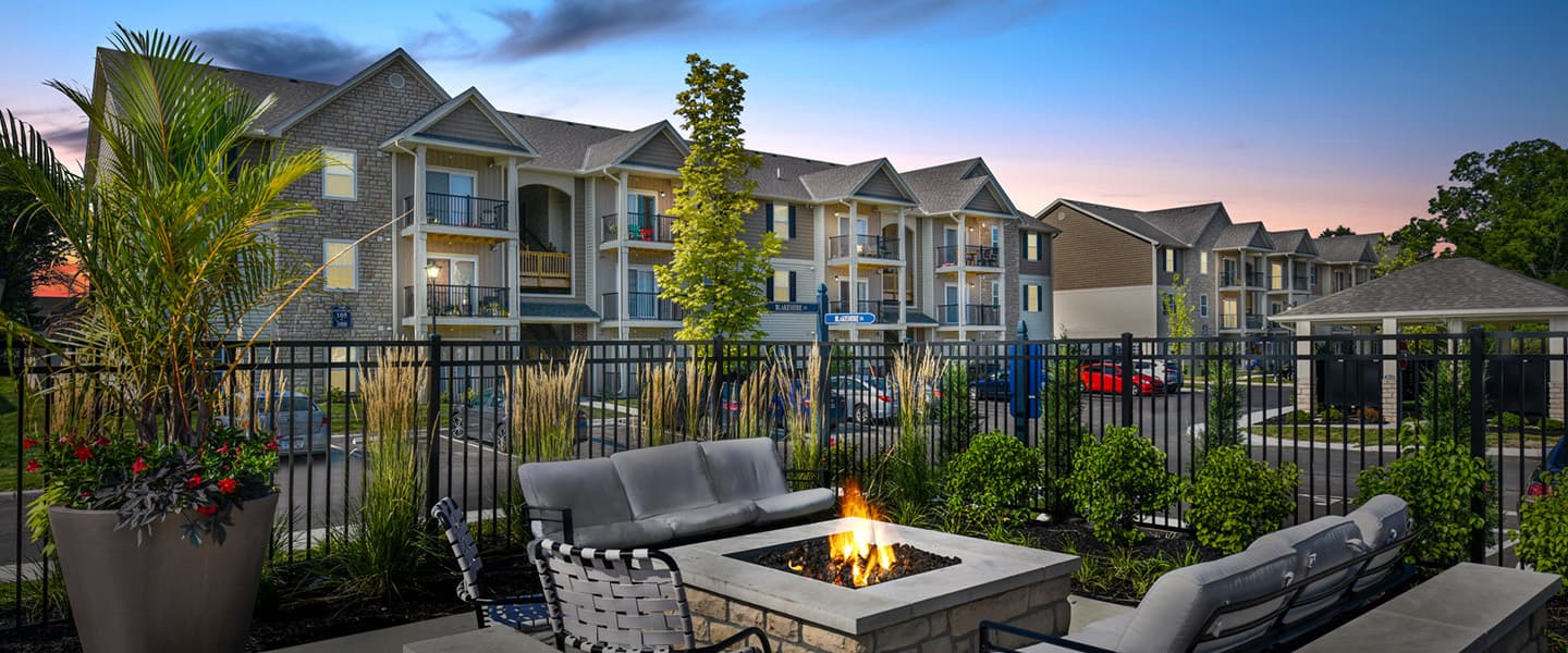 Outdoor seating around a firepit with the apartments in the background