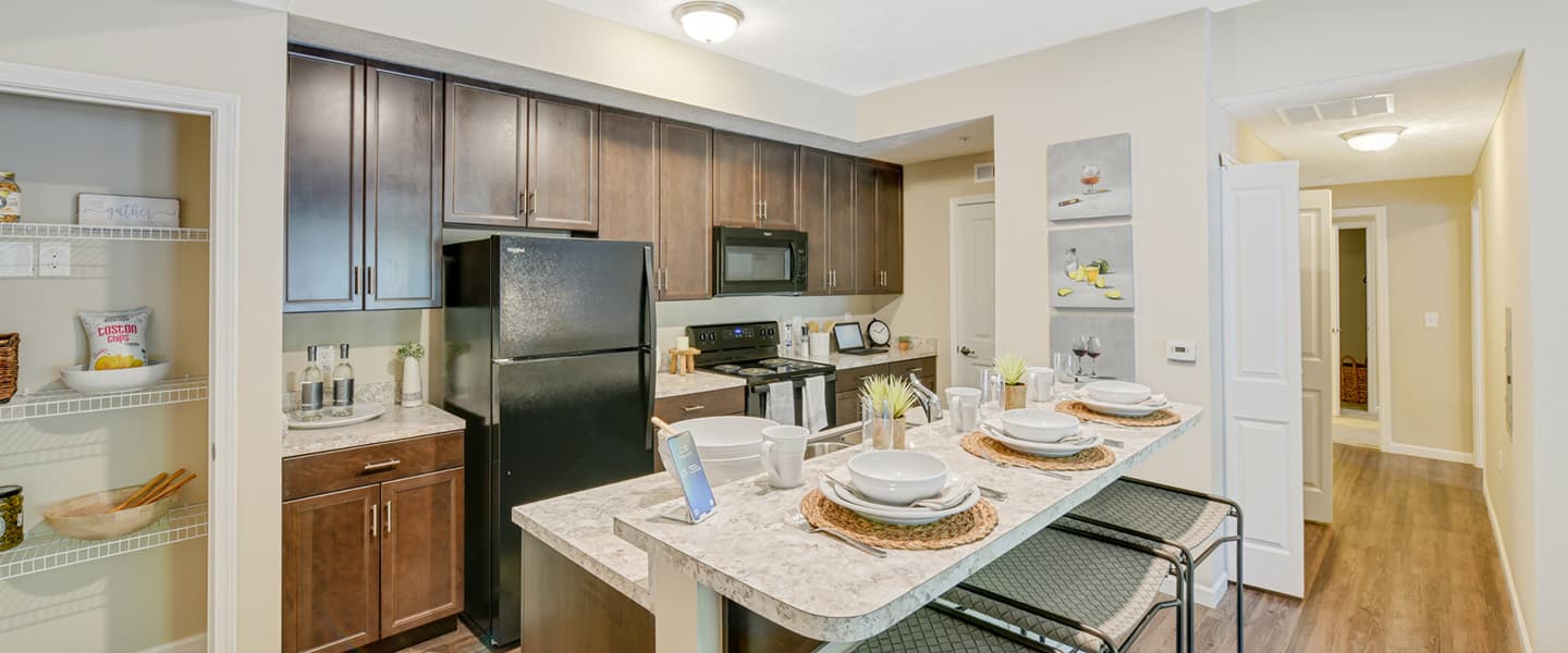Spacious kitchen with central island and black appliances