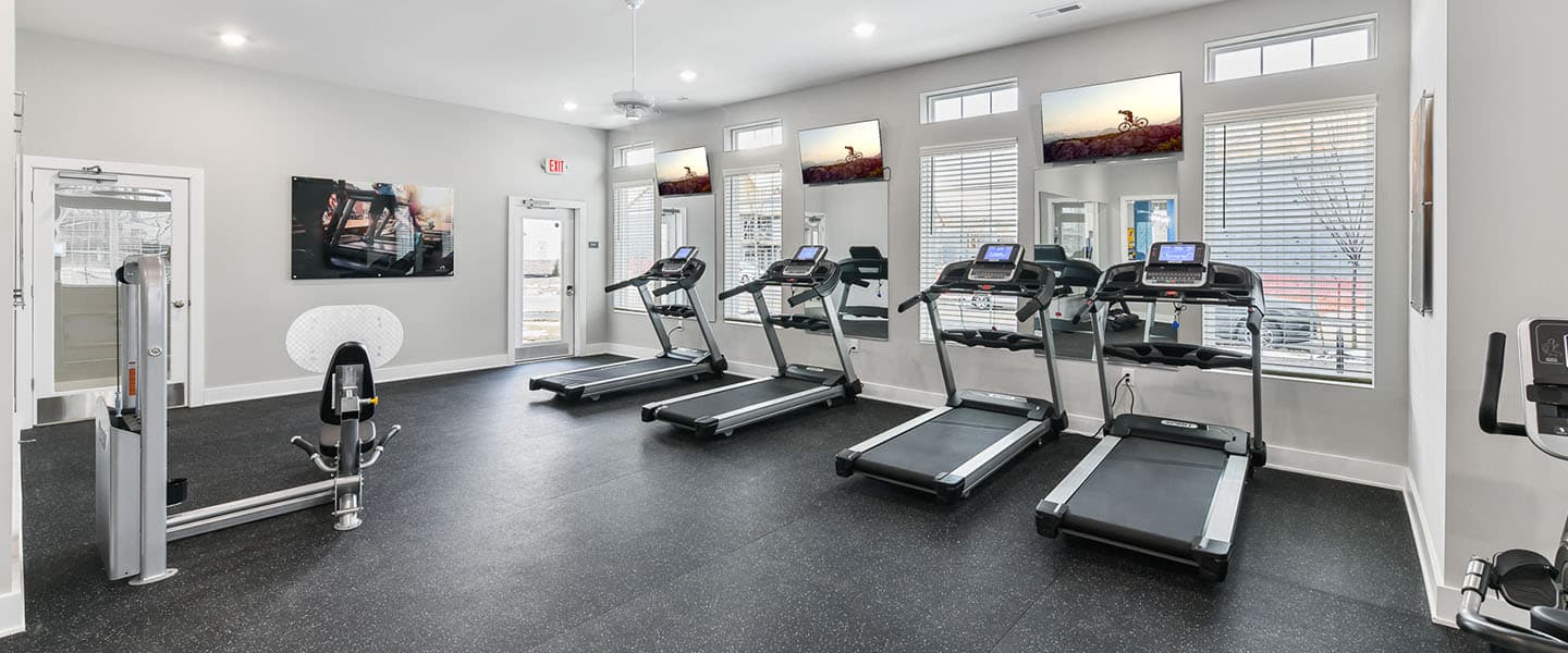 A modern community workout center with exercise equipment and natural light.
