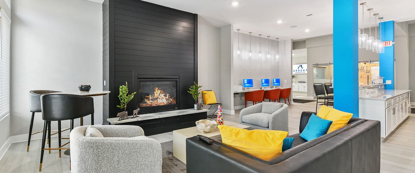 A community space complete with furniture, modern decor and a fireplace.