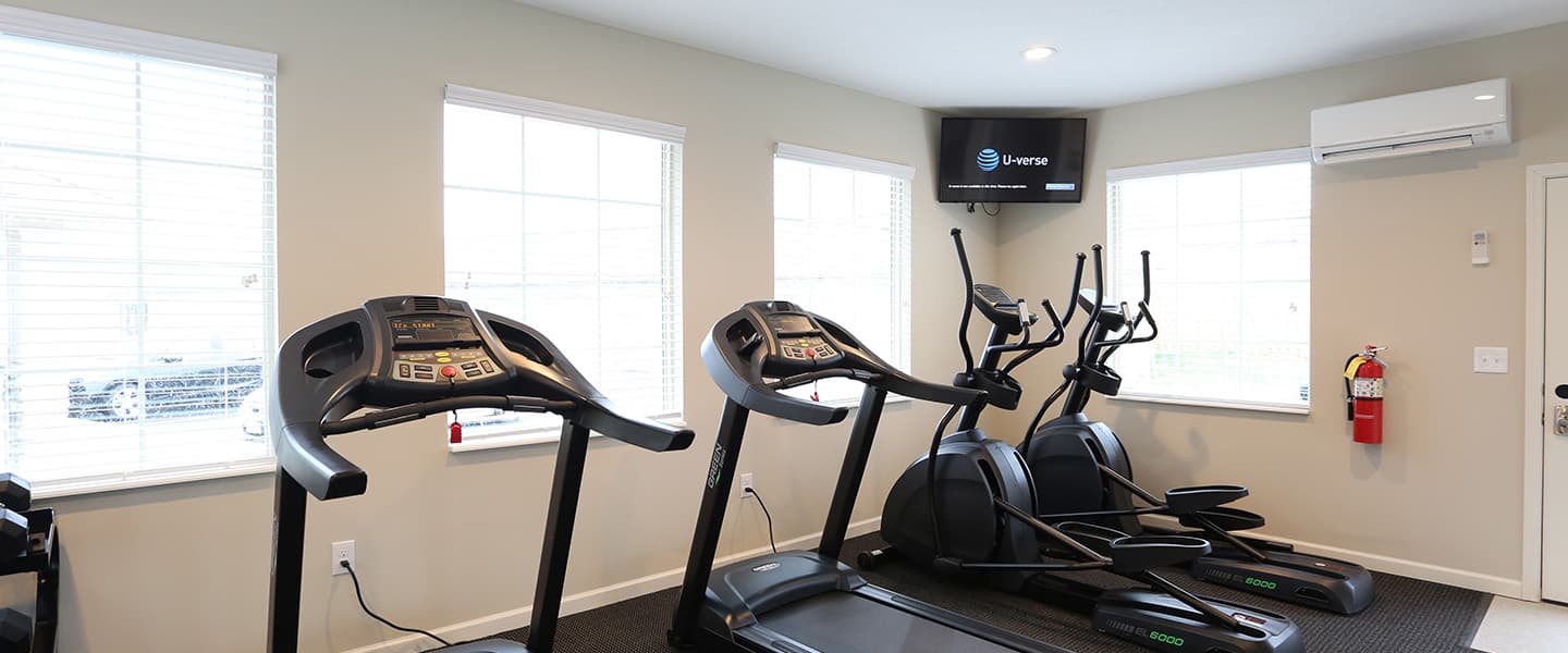 A modern community workout center with exercise equipment and natural light.