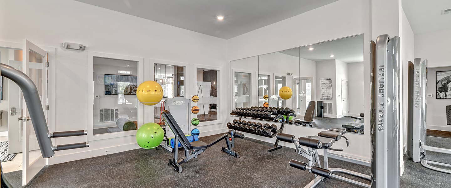 A modern community workout center with exercise equipment and natural light.