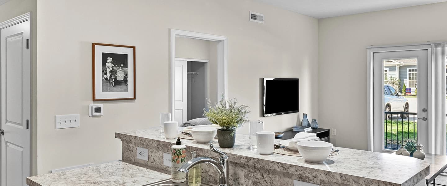 Kitchen island with view of living room and bedroom entrance