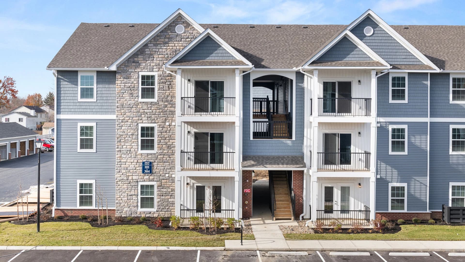 Exterior view of blue-painted three story apartment complex building in Grove City Ohio