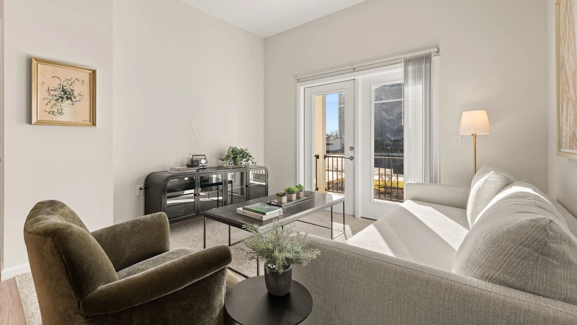 Cozy living room space with couch, chair, coffee table and entertainment center in a Grove City apartment unit