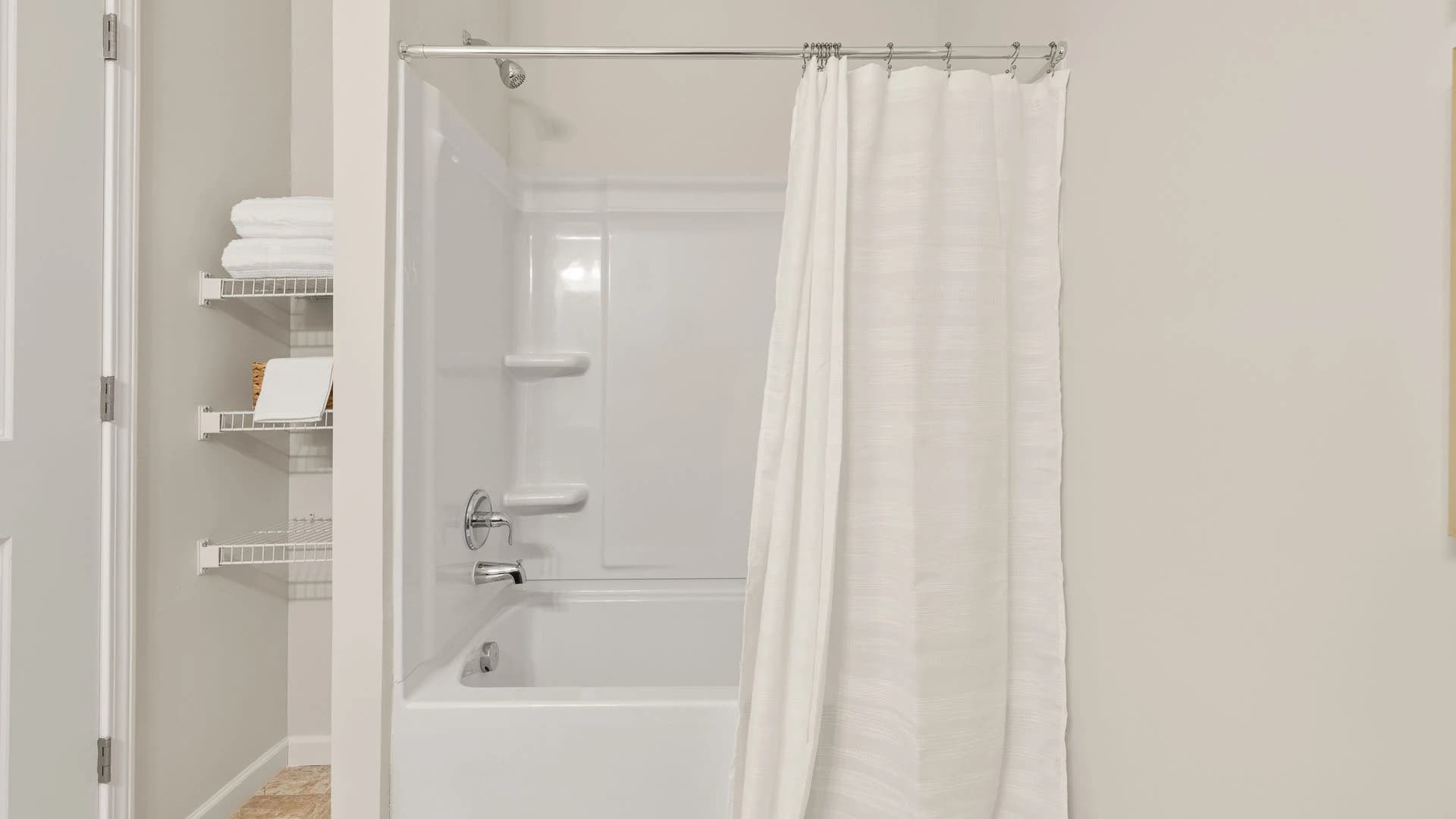 Shower and tub area next to storage space in the bathroom of a Grove City apartment unit