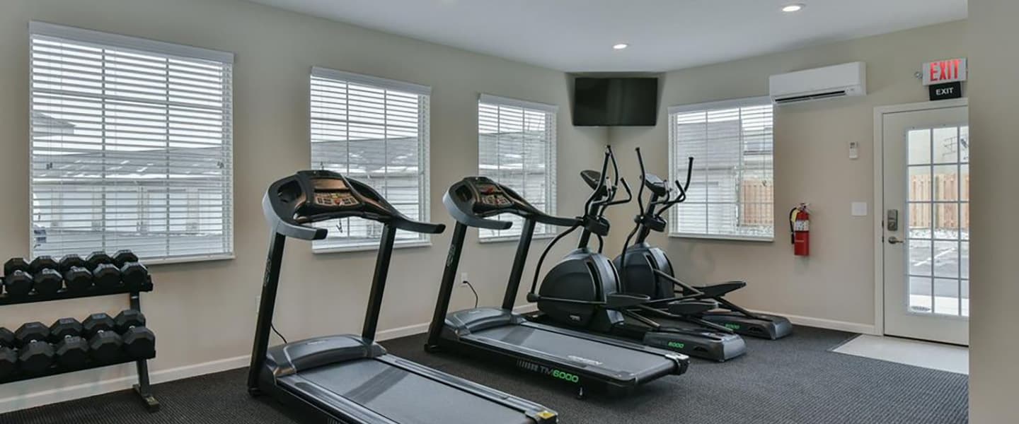 A modern community workout center with exercise equipment and natural light.