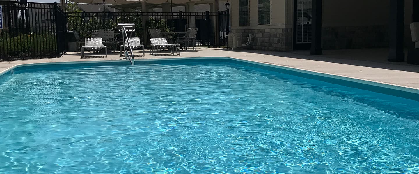 A beautiful swimming pool complete with outdoor seating and umbrellas.