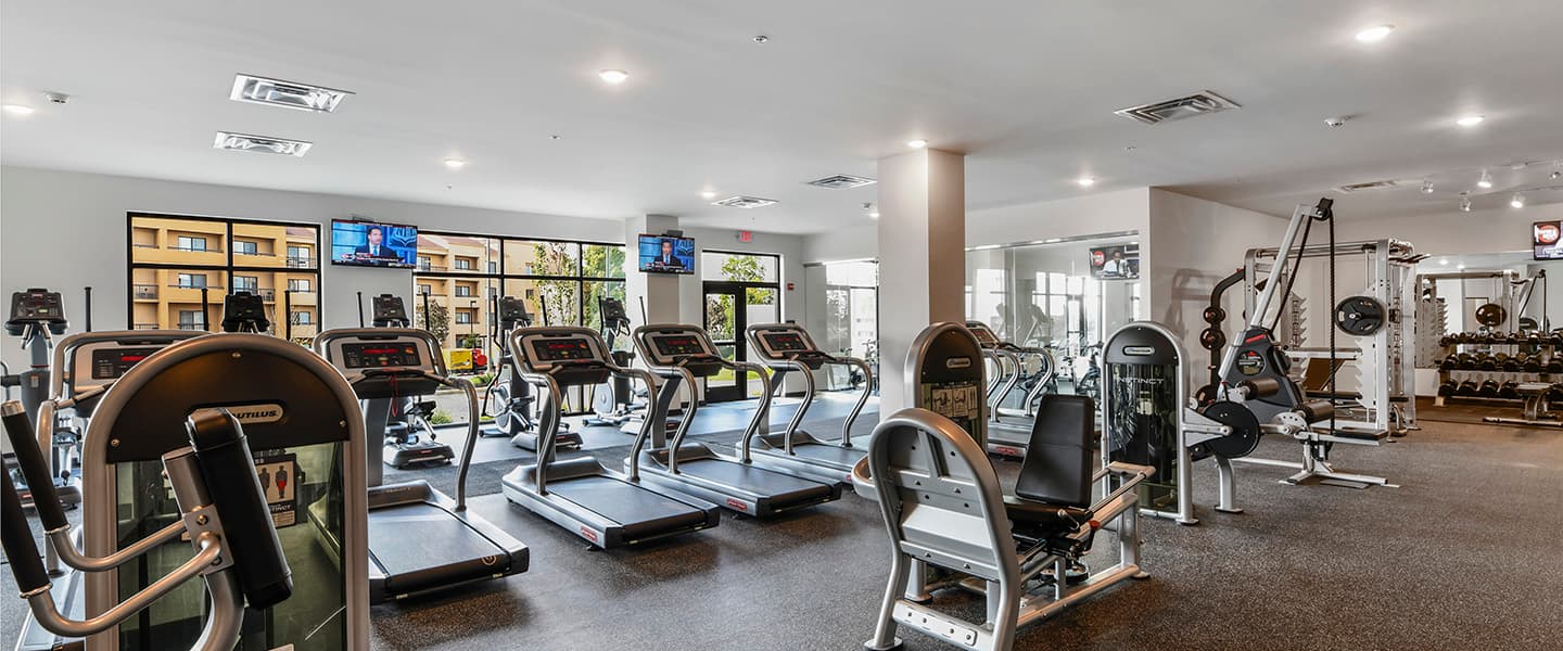 A modern community workout center with exercise equipment and natural light.