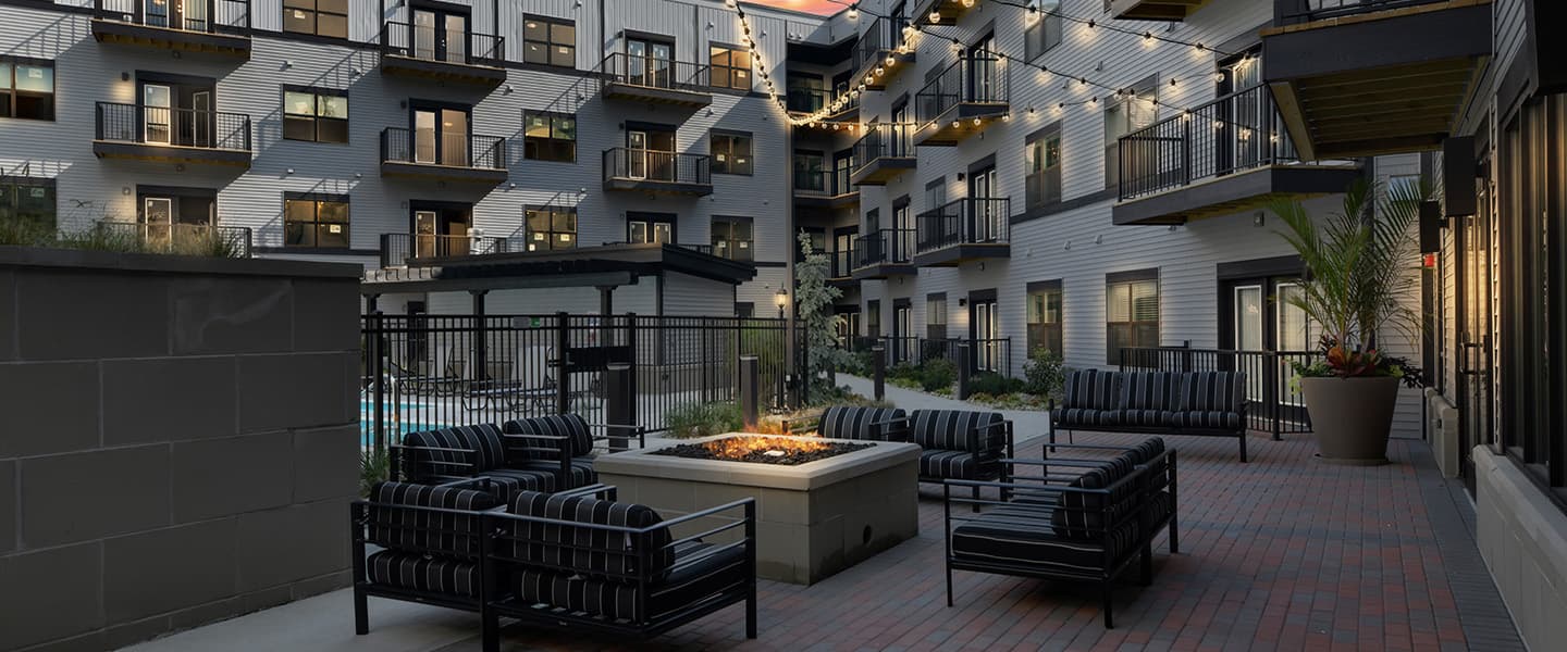 A beautiful outdoor seating area with a fireplace and modern decor.