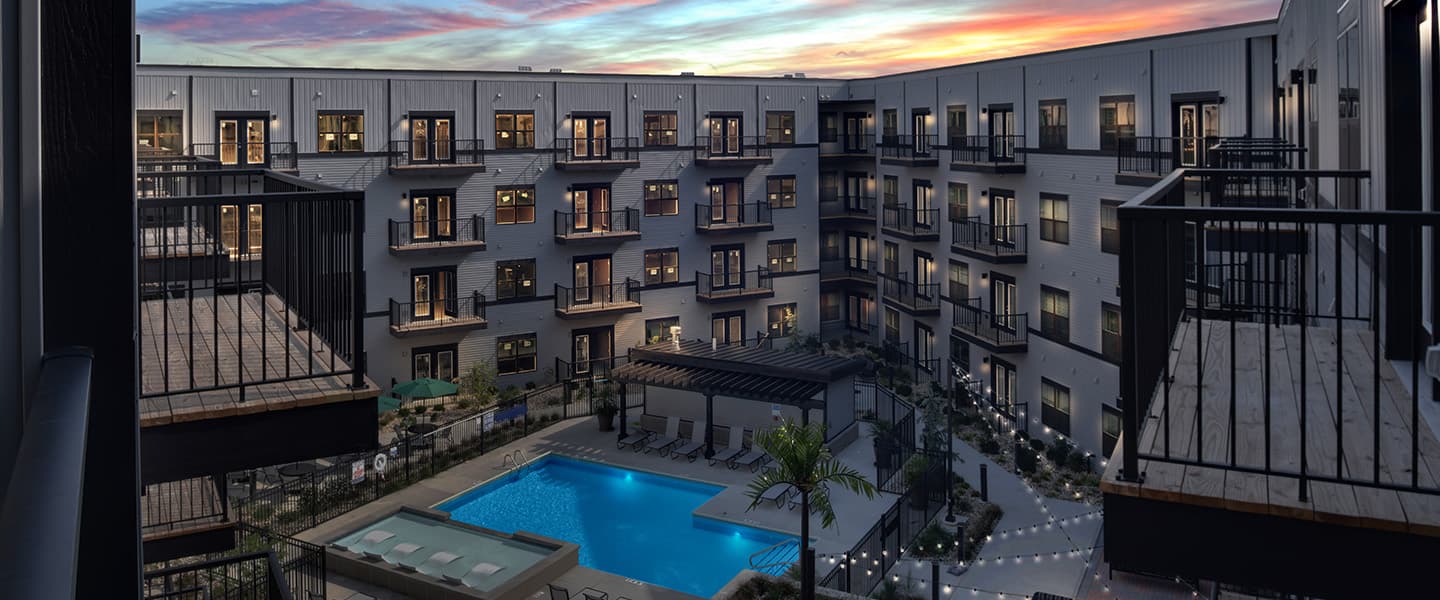 A beautiful pool complete with outdoor seating, umbrellas, and modern decor.