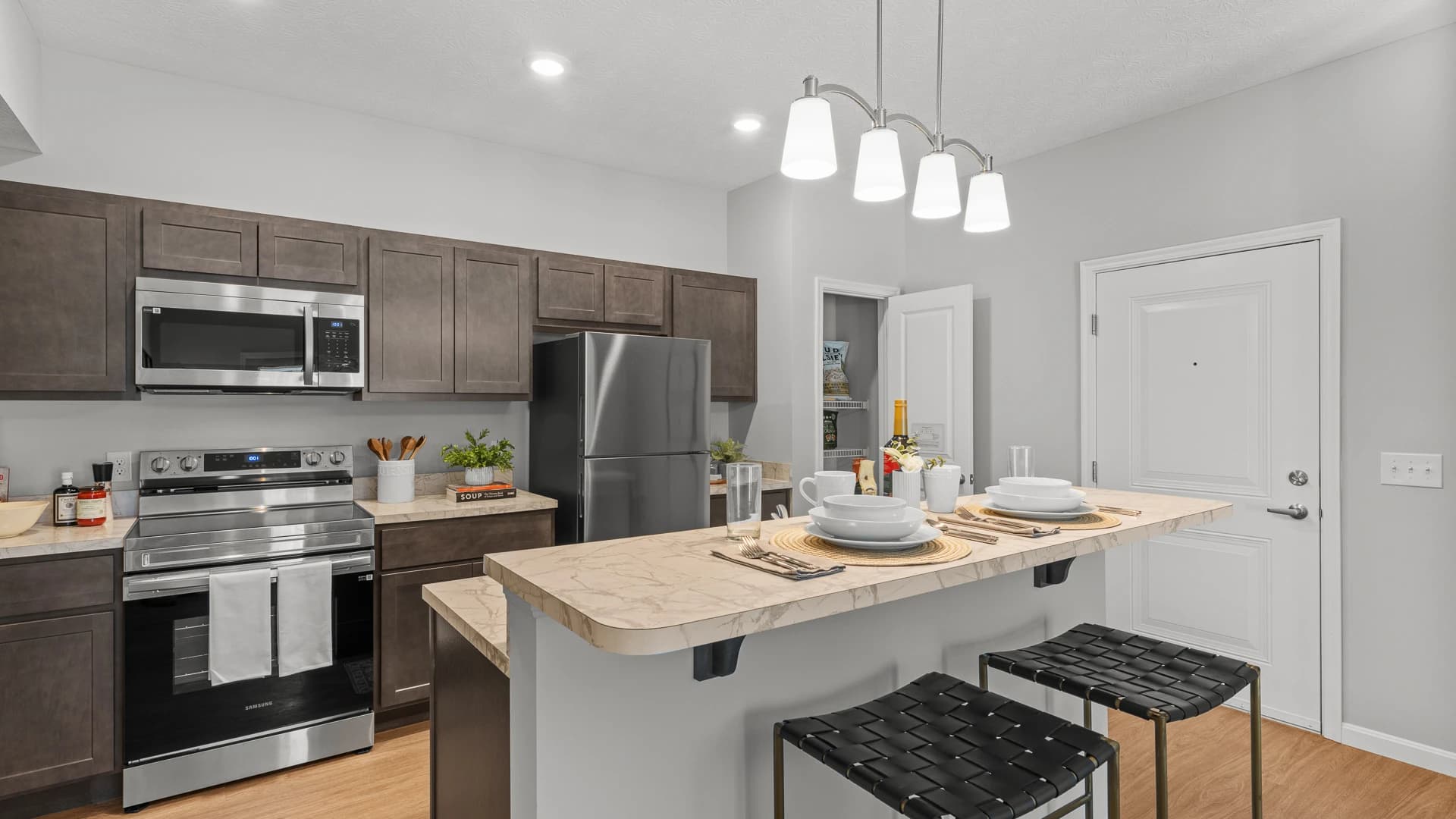 Kitchen scene including new appliances, pantry and island in a new Etna Ohio apartment unit