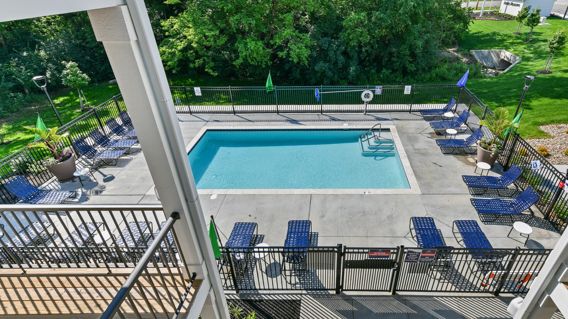 Overview of the pool with lounge seating at Alkire Meadows apartments