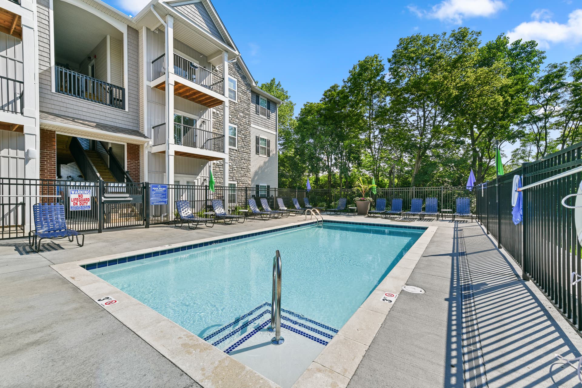 Resort-style pool with clear water and lounge seating for residents