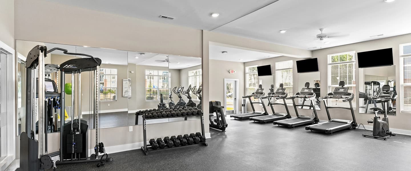 Fitness center featuring cardio machines and free weights for residents